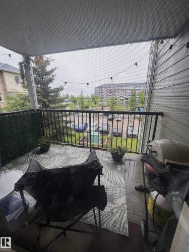 Covered balcony featuring a black metal railing and exterior siding - 317 6921 199 Street, Edmonton, AB 