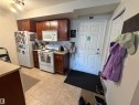 Kitchen featuring wood-finish cabinetry, light-toned countertops, and tile flooring - 317 6921 199 Street, Edmonton, AB 