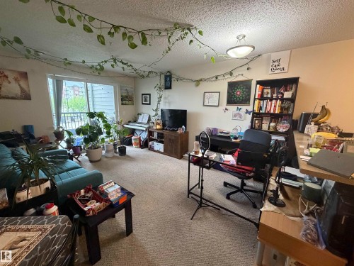 Living space featuring neutral carpeting, light-toned walls, and a textured ceiling - 317 6921 199 Street, Edmonton, AB 