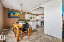 Open concept dining area featuring tile flooring and a kitchen beyond - 