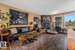 Living area featuring wood-finish flooring and a corner brick fireplace - 