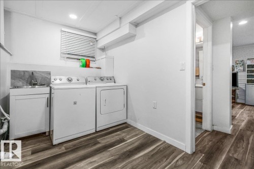 Dedicated laundry area featuring a utility sink with a white cabinet, washer, and dryer - 135 Homestead Crescent Nw, Edmonton, AB 