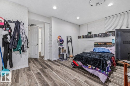 Room with wood-finish flooring, recessed lighting, and a white paneled door - 135 Homestead Crescent Nw, Edmonton, AB 
