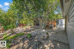 Extensive backyard featuring a flagstone patio, gravel pathways, and a raised wood deck with screened enclosure - 