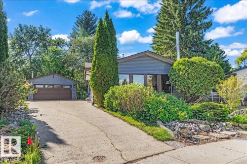 Contemporary-style residence featuring grey siding, a front-facing garage with a brown door, and a concrete driveway - 135 Homestead Crescent Nw, Edmonton, AB 