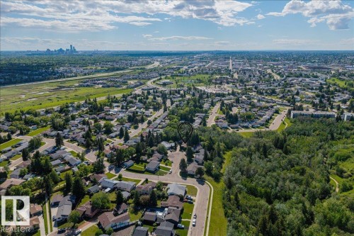 Aerial perspective showcasing a residential neighborhood with a prominent forested area - 135 Homestead Crescent Nw, Edmonton, AB 