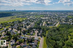 Aerial perspective showcasing a residential neighborhood with a prominent forested area - 