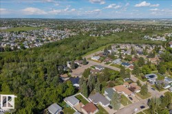 Aerial perspective showcasing a residential area interspersed with extensive green spaces and mature trees - 