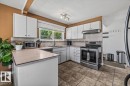 Kitchen featuring white cabinetry, light-toned countertops, a stainless steel range, and tile flooring - 135 Homestead Crescent Nw, Edmonton, AB 
