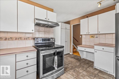 Kitchen featuring white cabinetry, stainless steel range, and tile flooring - 135 Homestead Crescent Nw, Edmonton, AB 