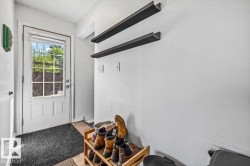 Entryway featuring a paneled door with glass inserts, transom window, and two wall-mounted shelves - 