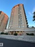 High-rise residential building featuring a prominent main entrance, multiple levels of private balconies with glass railings, and a distinct "The Cosmopolitan" façade signage - 1506 10909 103 Avenue Nw, Edmonton, AB 
