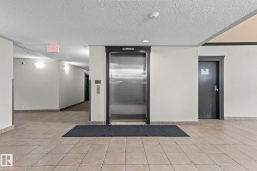 Central stainless steel elevator with dark trim - 2106 9357 Simpson Dr Nw, Edmonton, AB - Indoor Photo Showing Other Room