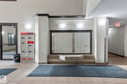 Interior common area featuring tile flooring, built-in mailboxes, and wall sconce lighting - 