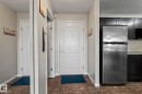 Entryway with a paneled white door, a full-length mirrored wall, tile flooring, and light-toned walls - 2106 9357 Simpson Dr Nw, Edmonton, AB  - Indoor Photo Showing Other Room 