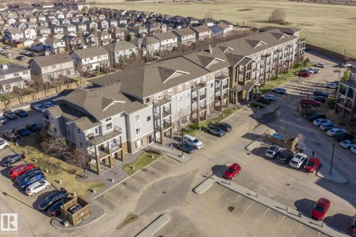 Multi-story residential building featuring light grey siding and dark brown stone accents - 2106 9357 Simpson Dr Nw, Edmonton, AB -  With View