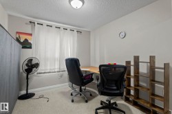 Room featuring neutral-toned walls, textured ceiling, and light-colored carpet flooring - 