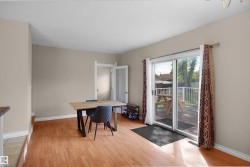 Wood-finish flooring throughout, featuring neutral wall paint and white trim - 
