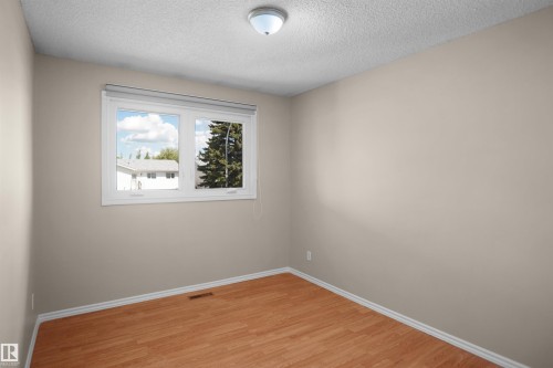 Bright room featuring wood-finish flooring and neutral wall tones - 13524 26 Street, Edmonton, AB 