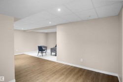 Expansive room featuring wood-finish flooring, light neutral wall paint, and recessed lighting - 