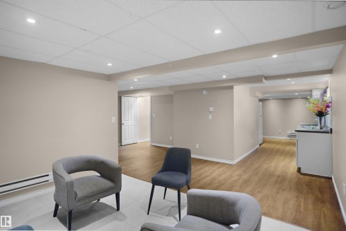 Spacious interior featuring a dropped ceiling with recessed lighting, light wood-finish flooring, neutral wall tones, and white trim - 13524 26 Street, Edmonton, AB 