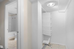 Interior hallway featuring light beige walls and a tile-look flooring - 