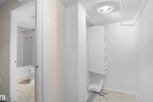 Interior hallway featuring light beige walls and a tile-look flooring - 13524 26 Street, Edmonton, AB 