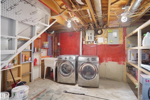 Basement utility area featuring exposed wood joists, concrete flooring, and a utility sink - 13524 26 Street, Edmonton, AB 