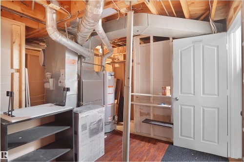Utility area with exposed ceiling joists and ductwork, featuring wood-finish flooring - 13524 26 Street, Edmonton, AB 