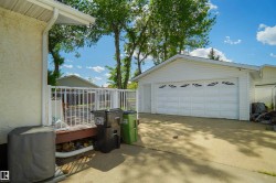 Detached two-car garage with white vinyl siding and decorative garage door windows - 