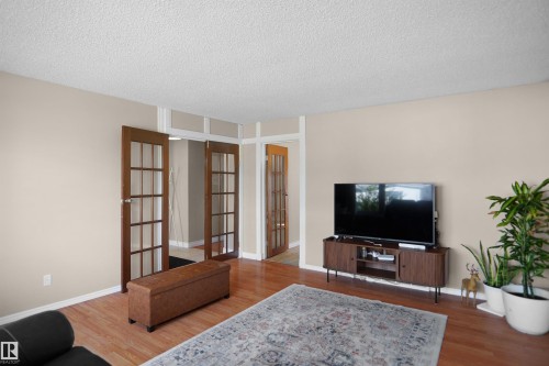 Warm wood-finish flooring complements the neutral wall tones - 13524 26 Street, Edmonton, AB 