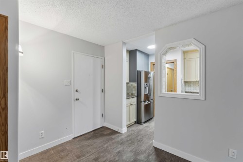 Interior featuring wood-finish flooring, light gray wall paint, and white baseboards - 121 5125 Riverbend Road Nw, Edmonton, AB 