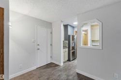 Interior featuring wood-finish flooring, light gray wall paint, and white baseboards - 