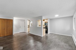 Spacious room featuring wood-finish flooring, light grey painted walls, and white trim - 