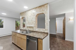 Kitchen island featuring a double-basin stainless steel sink, wood-finish cabinetry, and a stainless steel dishwasher - 