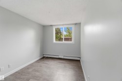 Neutral wall paint, wood-finish flooring, white trim, and a window with a white frame - 