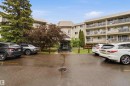 Multi-story residential building featuring a light-colored exterior and multiple private balconies - 121 5125 Riverbend Road Nw, Edmonton, AB 