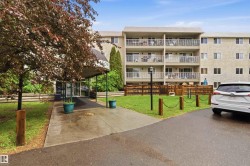 Multi-story building featuring a stucco exterior and multiple private balconies with glass railings - 