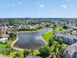 Expansive lakefront setting featuring a defined shoreline, surrounding green spaces, and dense neighborhood development - 