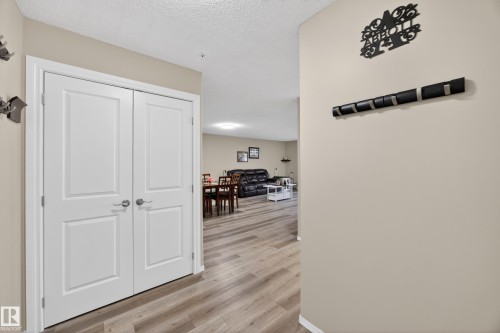 Hallway with light beige walls and wood-finish flooring - 138 16035 132 Street, Edmonton, AB 