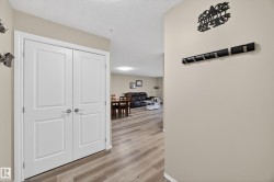 Hallway with light beige walls and wood-finish flooring - 