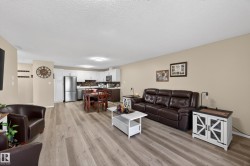 Open-concept main living area with wood-finish flooring - 