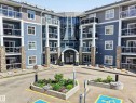 Modern multi-story building featuring a prominent glass-enclosed entrance - 138 16035 132 Street, Edmonton, AB 