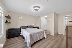 Bedroom featuring wood-finish flooring, neutral wall paint, and a white window frame - 