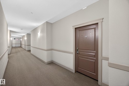 Interior corridor featuring textured carpeting and neutral wall tones - 138 16035 132 Street, Edmonton, AB 