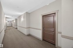 Interior corridor featuring textured carpeting and neutral wall tones - 