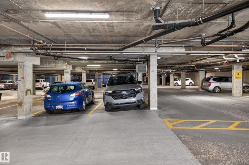 Underground parking garage featuring concrete flooring and exposed concrete ceilings - 138 16035 132 Street, Edmonton, AB 