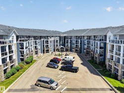 Contemporary apartment building with blue siding and stone accents, featuring multiple private balconies with glass railings - 