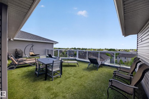 Rooftop patio with artificial turf flooring and a transparent glass railing - 138 16035 132 Street, Edmonton, AB 