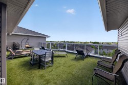 Rooftop patio with artificial turf flooring and a transparent glass railing - 